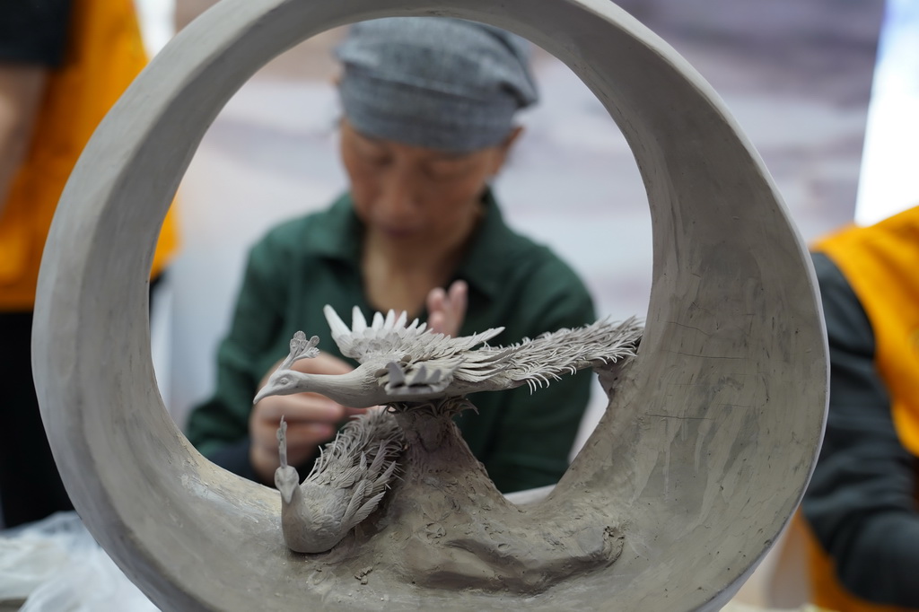 10月18日，在瓷博會瓷都工匠技藝展示館，一名“瓷都工匠”在展示捏雕技藝。新華社記者 周密 攝