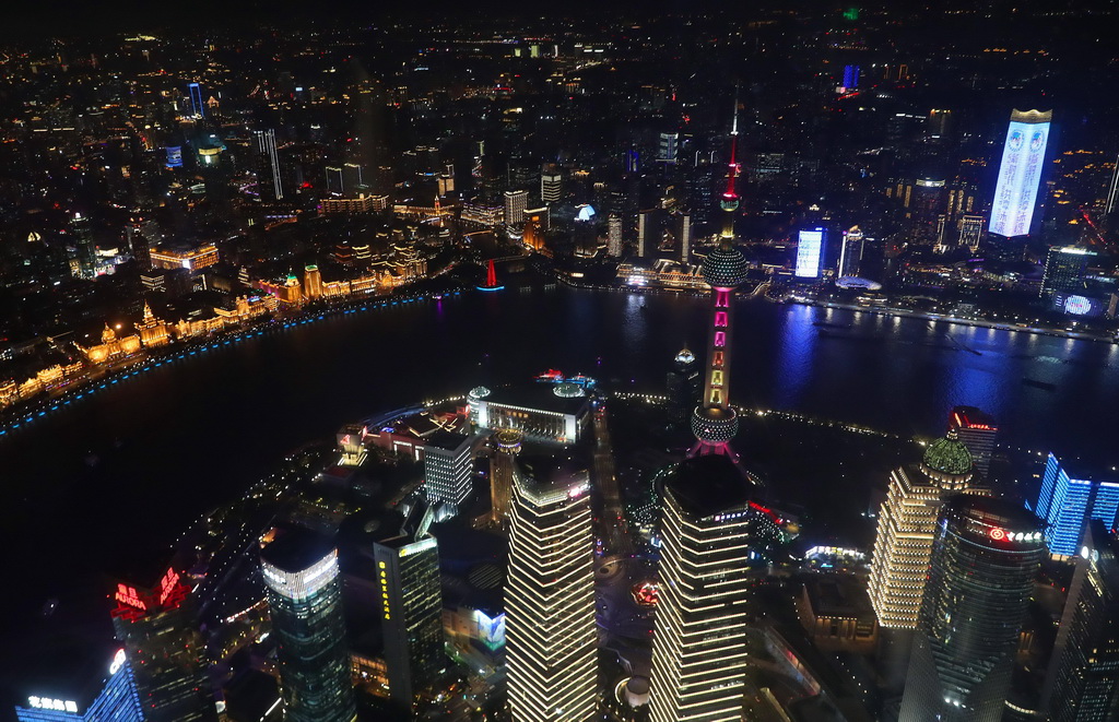 11月3日，从上海中心观光厅俯瞰市区夜景，浦西白玉兰广场（右上）在楼身上亮起第六届进博会宣传彩灯。新华社记者 方�� 摄