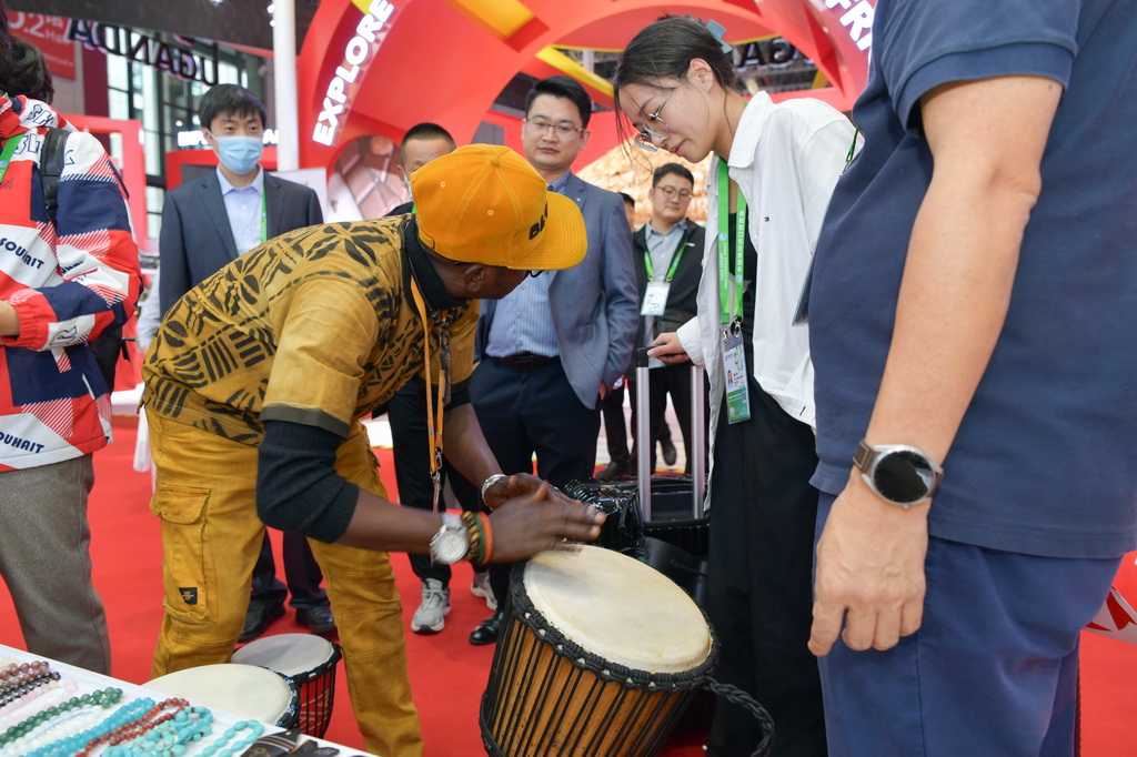 11月8日，在第六屆進博會國家展馬裡共和國館，展商向觀眾介紹非洲鼓。新華社記者 孟濤 攝
