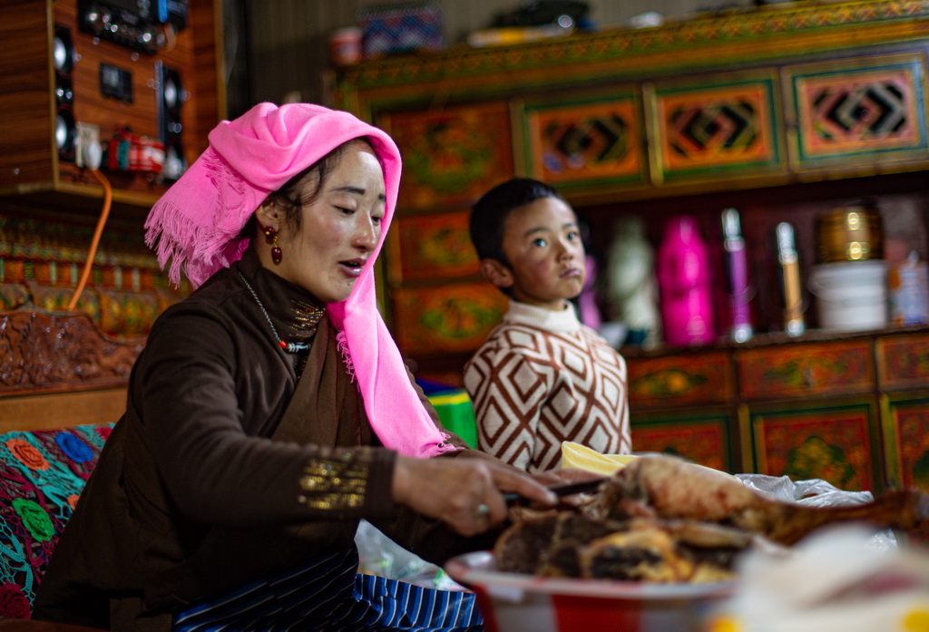 西藏當雄縣納木湖鄉達布村的冬季放牧點上，牧民芝嘎措姆在給兒子多吉扎西切牛肉（11月10日攝）。新華社記者 晉美多吉 攝