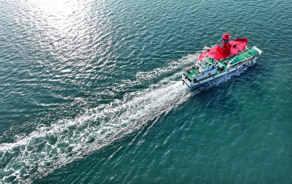 11月15日，青岛航标处一艘工作船将新的航标灯船送往作业海域（无人机照片）。