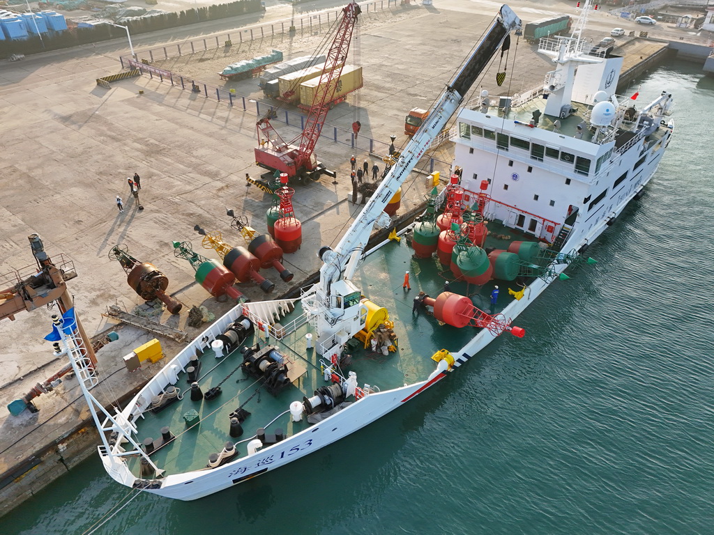 11月21日，在山東龍口港，吊車將航標裝上“海巡153”航標船（無人機照片）。