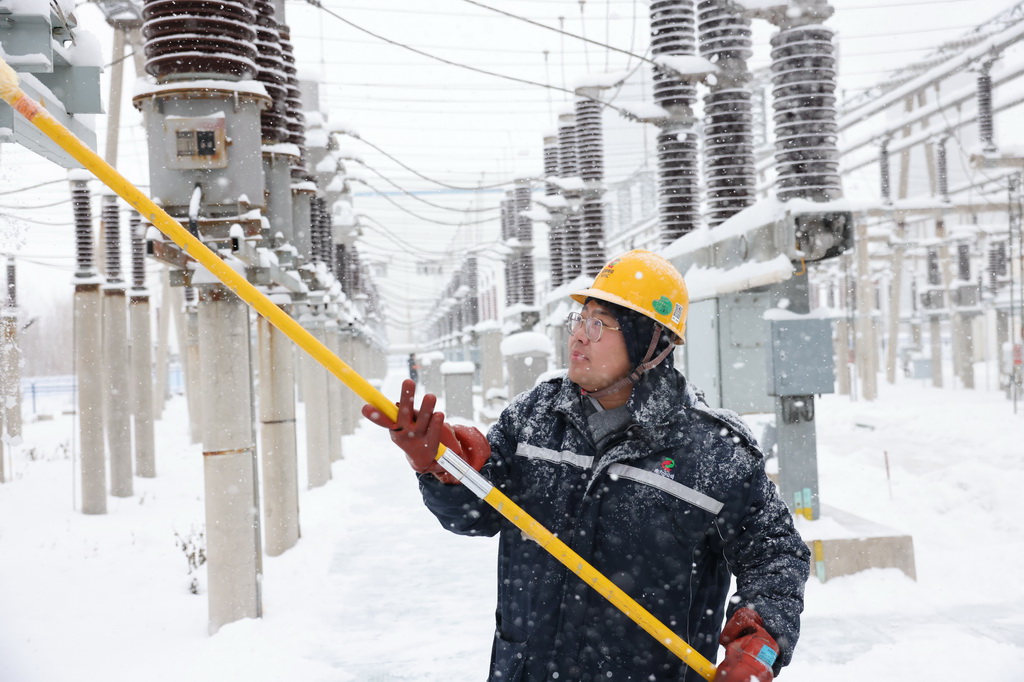 11月22日，国家电投内蒙古公司电力分公司职工在清扫绝缘瓷瓶。新华社发（程谋举 摄）