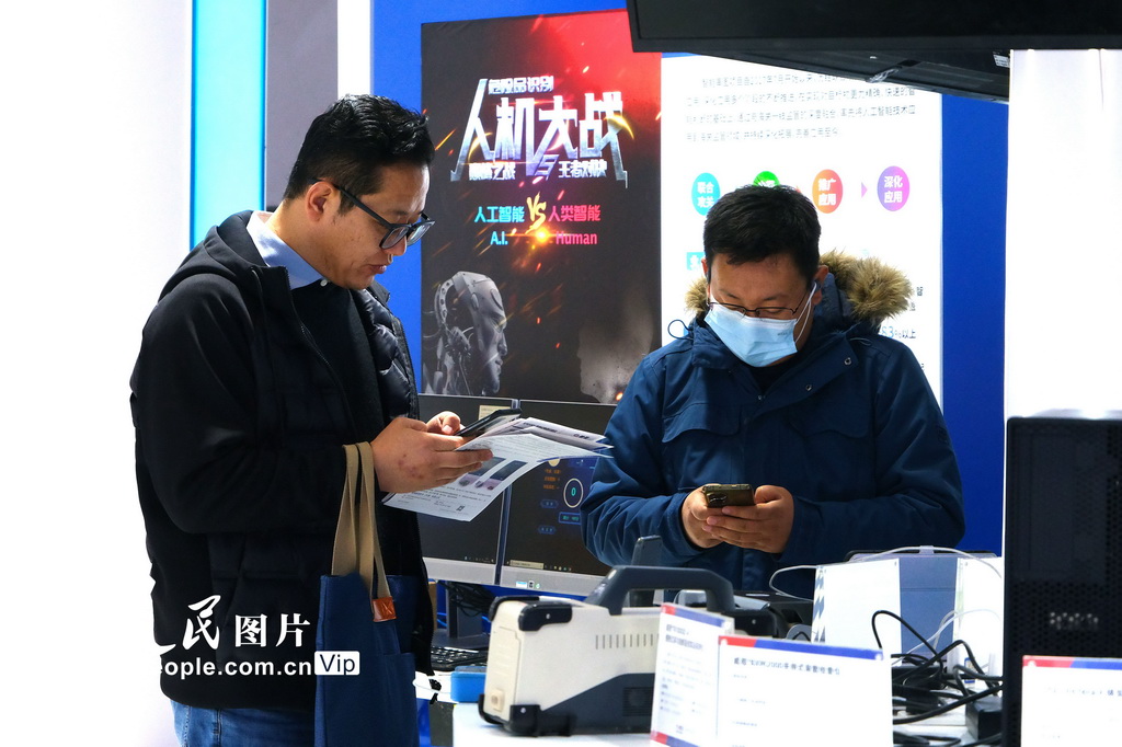 11月26日，观众在国展中心通过手机扫码了解相关产品信息。