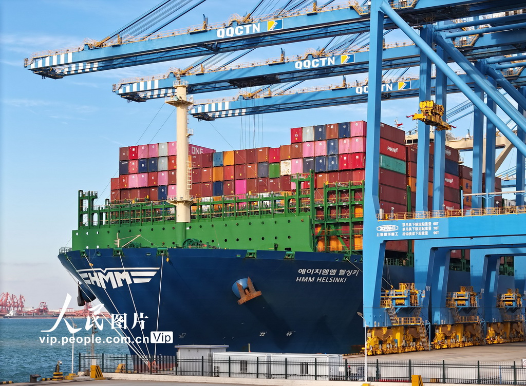 11月30日，在山东港口青岛港，一艘货轮在装卸货物。