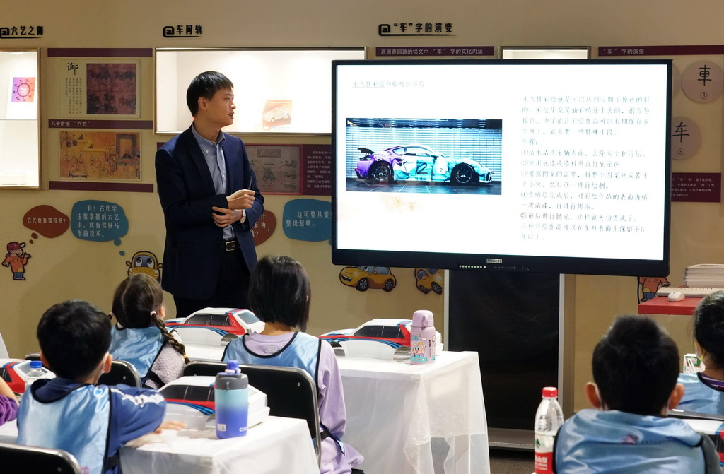 12月9日，北京汽車博物館的工作人員向小朋友介紹汽車彩繪知識。