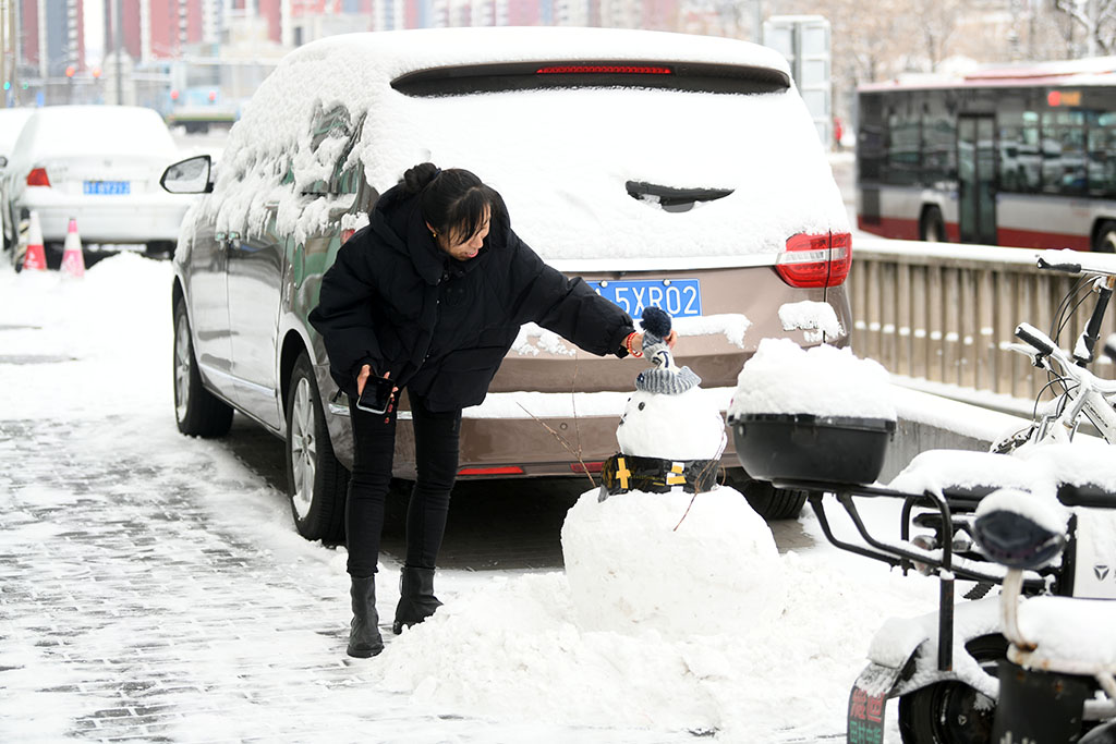 2023年12月11日，北京迎來降雪，市民正在堆雪人。人民網記者 於凱攝