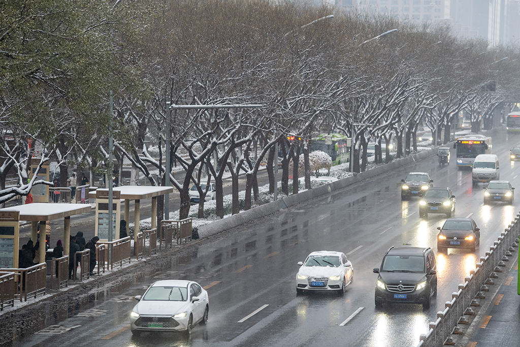 2023年12月11日，北京建國路，車輛在雪中行駛。人民網記者 翁奇羽攝