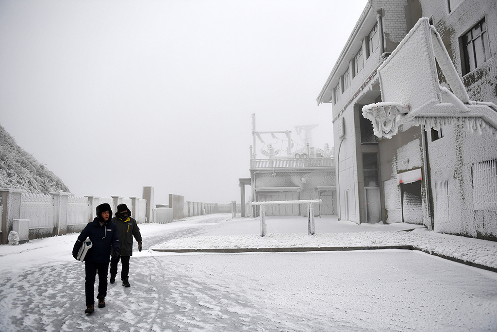 12月18日，尹斌（左）和龍昱君觀測覆冰情況后返回西晃山風電場。新華社記者 陳振海 攝