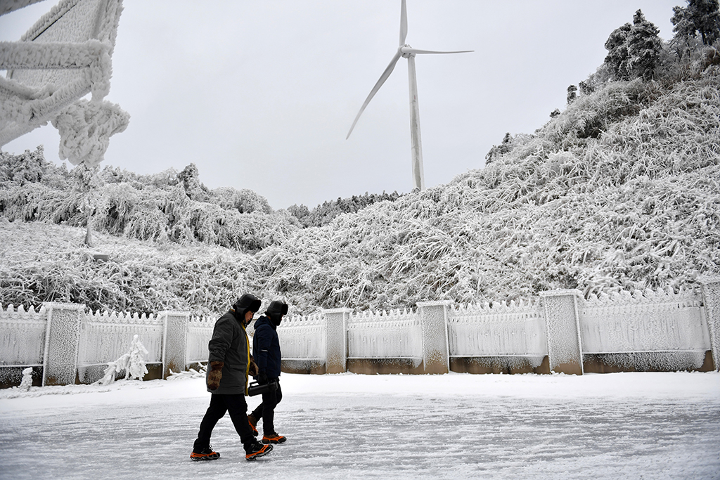 12月19日，尹斌（右）和龍昱君前往110千伏西公線003號監測哨所觀測冰情。新華社記者 陳振海 攝