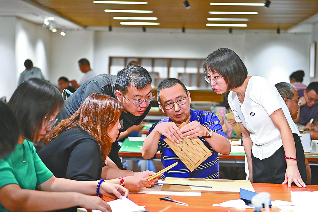 山西省圖書館，來自國家圖書館的古籍修復專家劉建明（右二）在給該省第一期古籍修復培訓班的學員們講解古籍修復技巧。