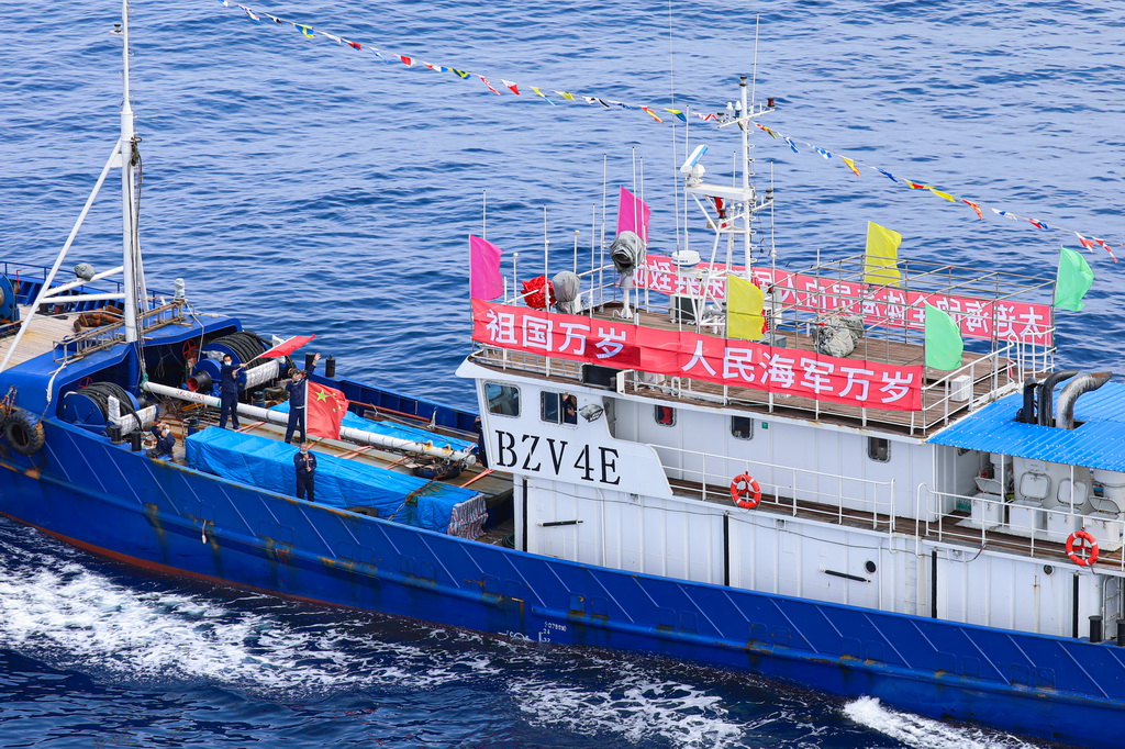 被護船隻、中國籍遠洋漁船“海欣29”號挂起“祖國萬歲”“人民海軍萬歲”等字樣的橫幅（2022年6月4日攝）。新華社發（楊捷攝）