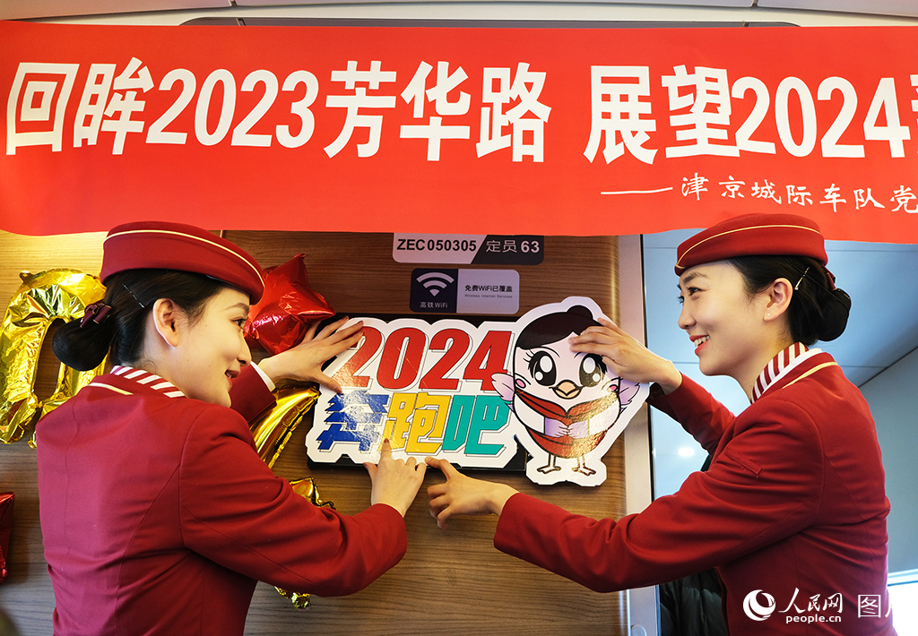 2023年12月31日，乘務人員在C2024次列車上布置車廂營造節日氛圍。