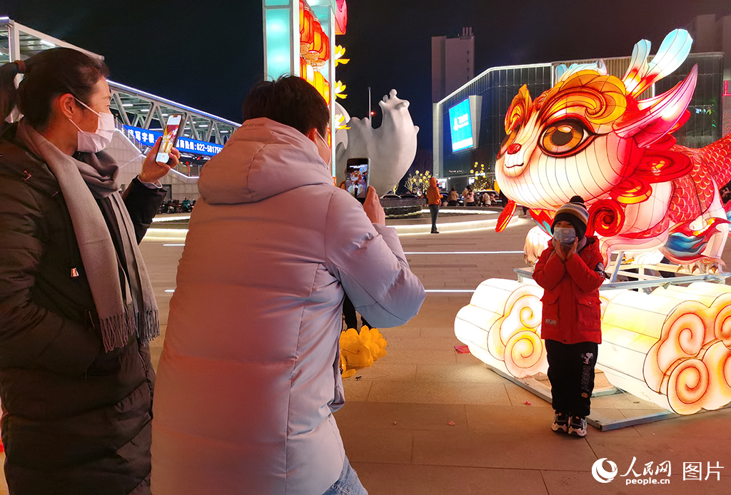 2023年12月31日，天津市民在西青大悅匯龍形燈飾前拍照留念。人民網記者 陶建攝