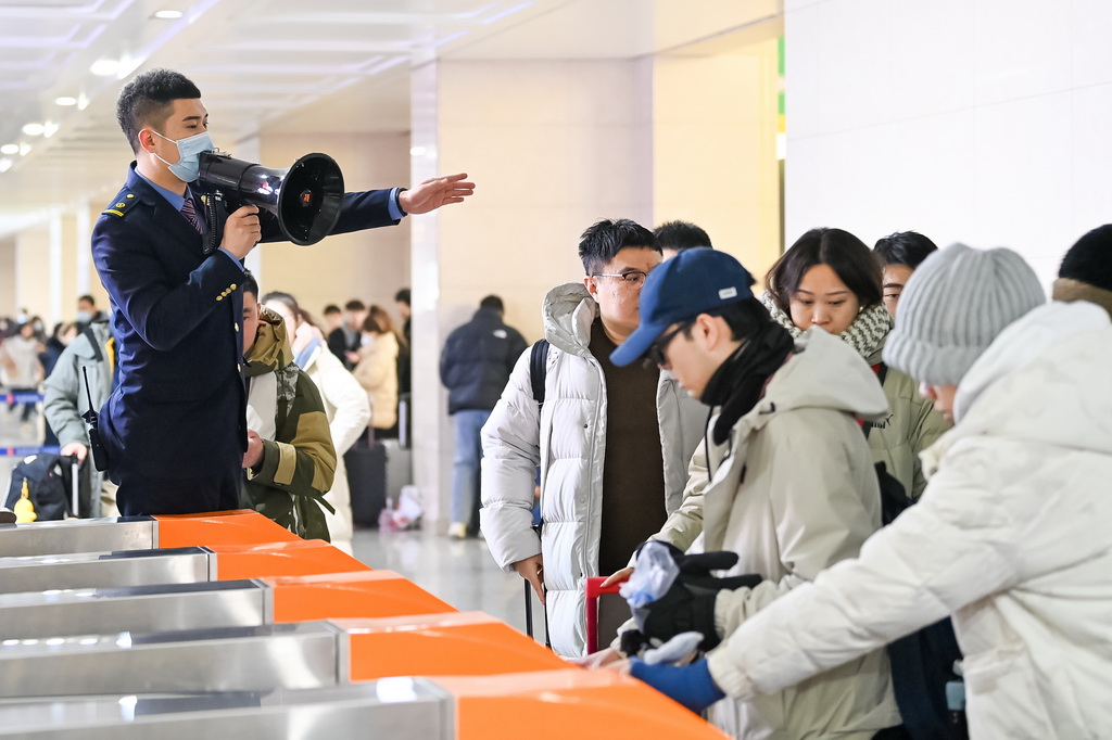  1月1日，哈爾濱火車站值班人員引導乘客有序通過閘機。新華社發（原勇 攝）