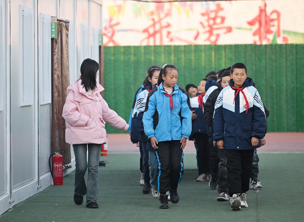 1月2日，在青海省海東市民和回族土族自治縣官亭鎮中心學校，學生前往操場參加升旗儀式。新華社記者 張子琪 攝