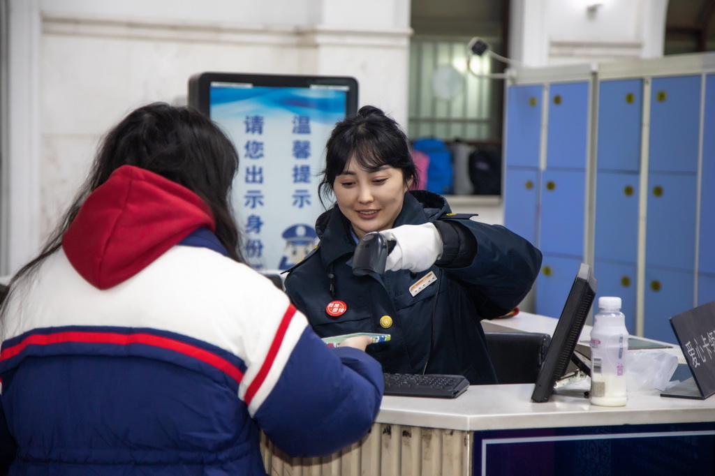 1月2日，沈陽站客運員徐楊在查驗旅客乘車信息。新華社發（韓慶瀟攝）