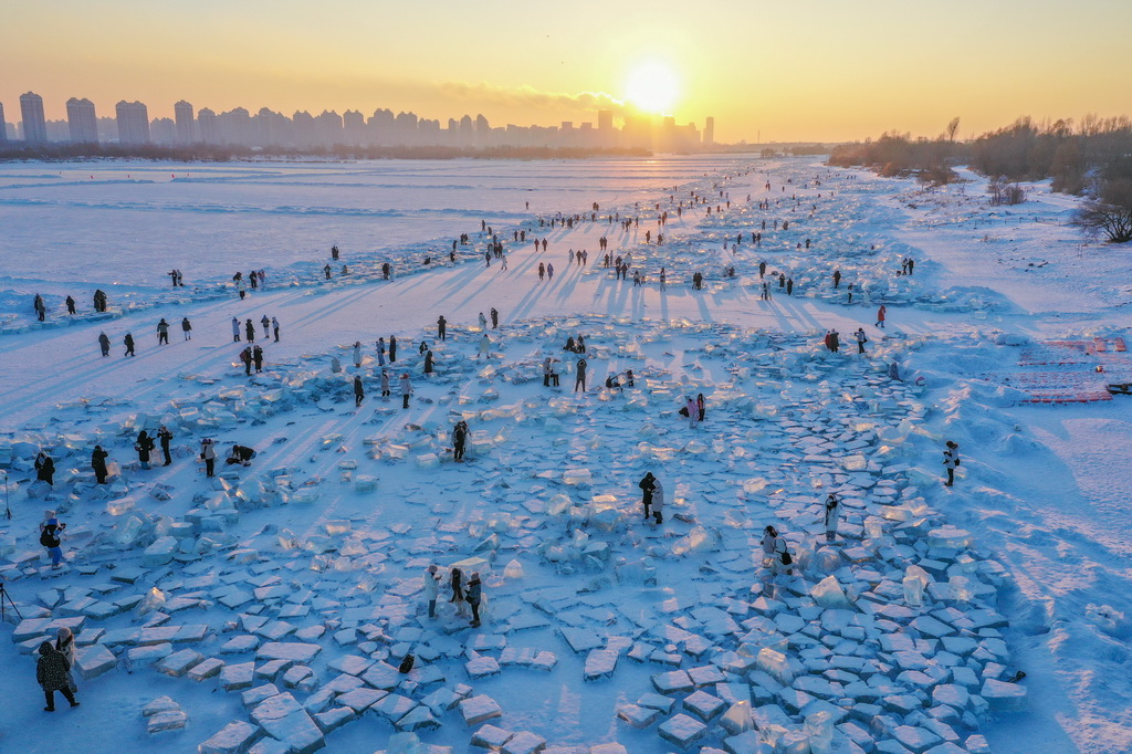 1月7日，在封凍的鬆花江哈爾濱段，游客在日落時分的“鑽石海”游玩（無人機照片）。