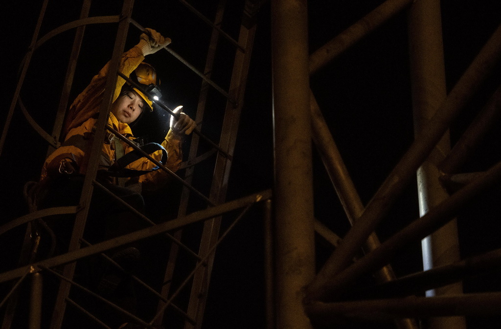 1月12日，在重慶興隆場編組站，母思琪通過上下扶梯准備登上燈橋開展檢修作業。