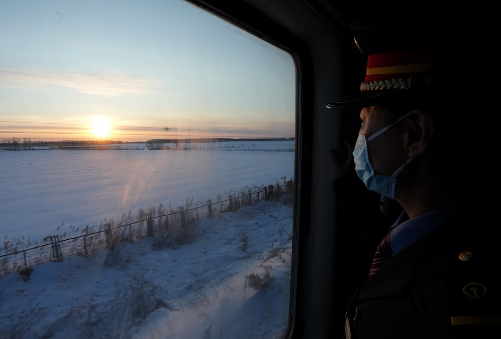 1月23日，在哈爾濱開至撫遠的K7065次列車上，通宵值班的列車員迎接日出。新華社記者 王毓國 攝