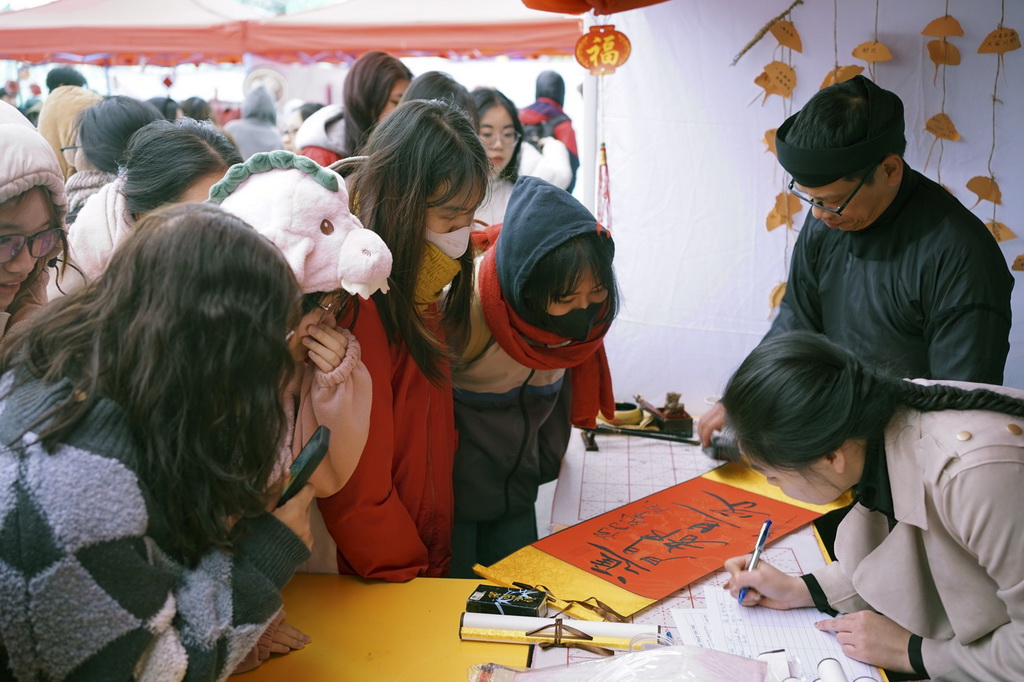 1月24日，“歡慶春節暨中越年俗文化交流體驗”活動在越南河內的河內大學舉辦，約500名學生及社會各界人士參加了書法、中國畫、剪紙、奧黛漢服秀和歌舞表演等體驗活動，還品嘗了春卷、粽子、餃子、湯圓等傳統美食。這是越南學生在活動中等待領取書法作品。新華社記者 胡佳麗 攝