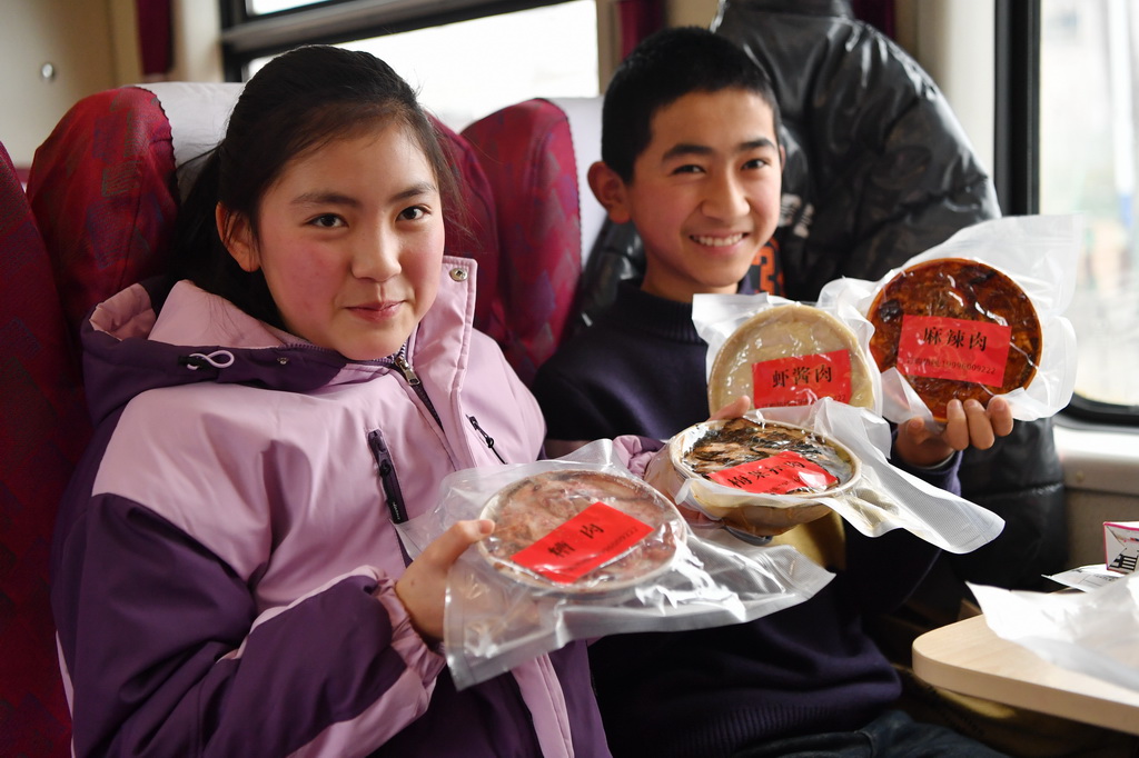 旅客在7503次列車上展示自己購買的年貨食品（2月4日攝）。新華社記者 方欣 攝