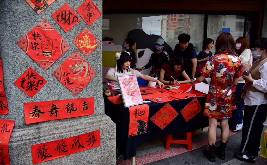 2月3日，在台北市迪化街的一處春聯攤，幾名年輕女子在為人們現場創作創意春聯。新華社記者 陳鍵興 攝