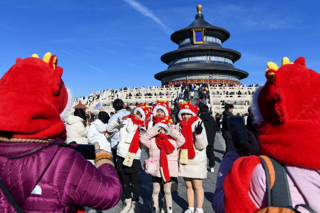 幾名來自馬來西亞的游客戴著“龍”帽在天壇公園游玩（1月23日攝）。新華社記者 鞠煥宗 攝