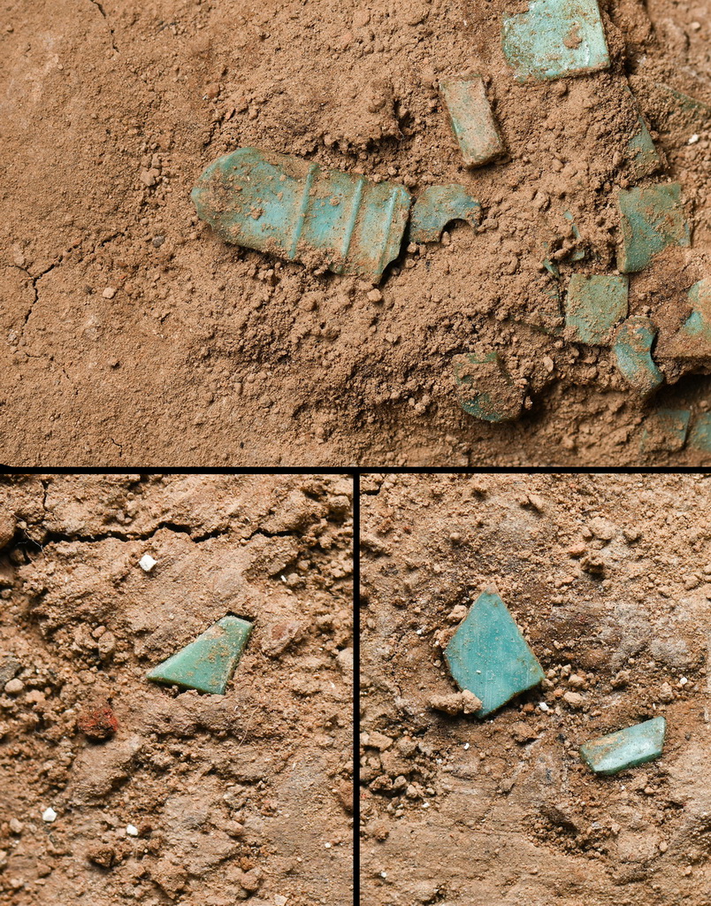 這是一張拼版照片。上圖：距離綠鬆石龍形器“龍尾”4厘米處的綠鬆石條形飾中，一片雕刻有凸弦紋的飾片與眾不同。下圖：散布在綠鬆石龍形器旁邊經過精心打磨的綠鬆石飾片（2024年1月29日攝）。新華社記者 李賀 攝