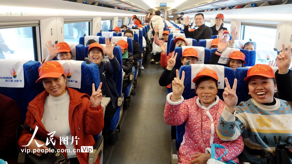 2月15日，廣西河池市返廠復工人員高興地乘坐免費高鐵。高東風攝（人民圖片網）