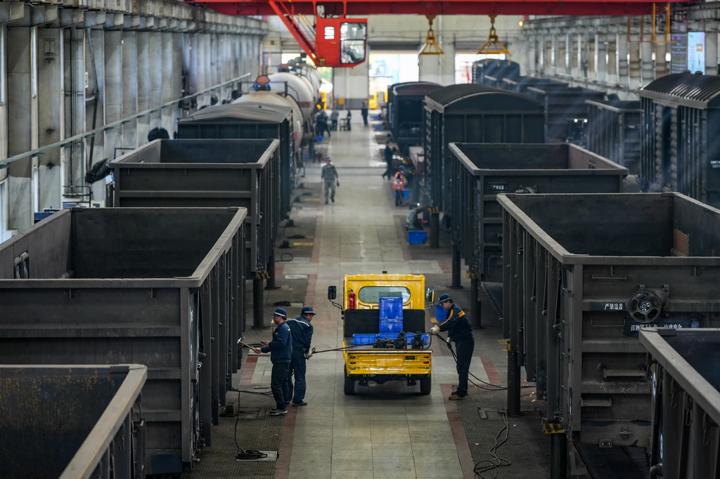 2月18日，在貴陽南車輛段檢修車間，工作人員對貨運列車車體進行檢修。新華社發（龍建睿攝）