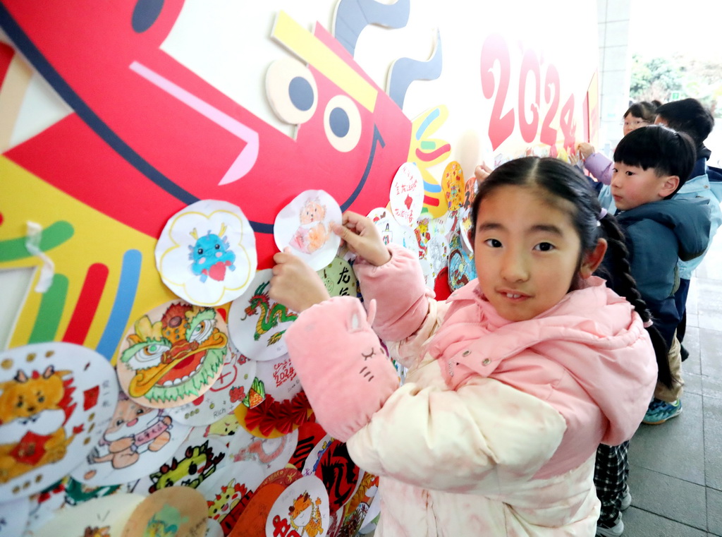 2月20日，在江蘇省蘇州市金閶實驗小學校，小學生在“龍年幸福牆”上貼上自制的心願卡。新華社發（杭興微攝）