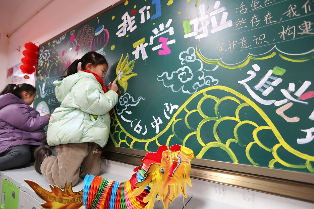 2月20日，學生在江蘇省連雲港市院前小學二年級的教室裡准備開學第一課板報。新華社發（王春攝）