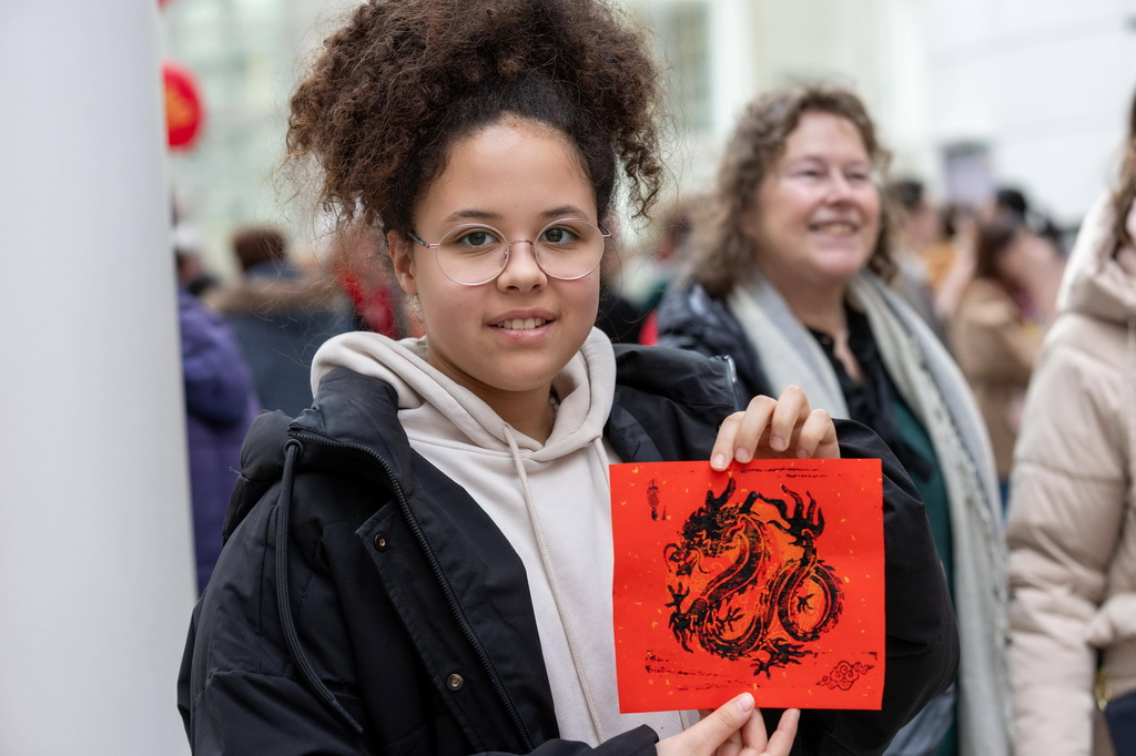 2月24日，一名觀眾在荷蘭海牙市政廳展示龍年年畫。當日，“福龍迎新春”暨元宵節廟會活動在荷蘭海牙市政廳舉行。新華社記者 孟鼎博 攝