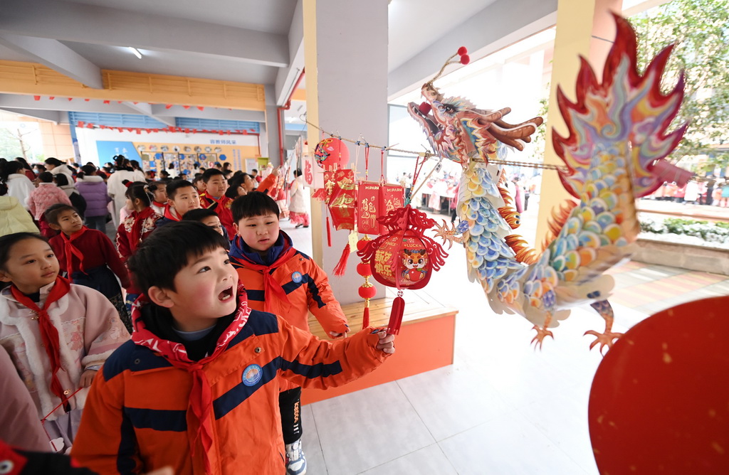 2月26日，湖北省襄陽市海容小學學生在校園觀賞剪紙繪畫燈籠等作品。新華社發（謝勇 攝）