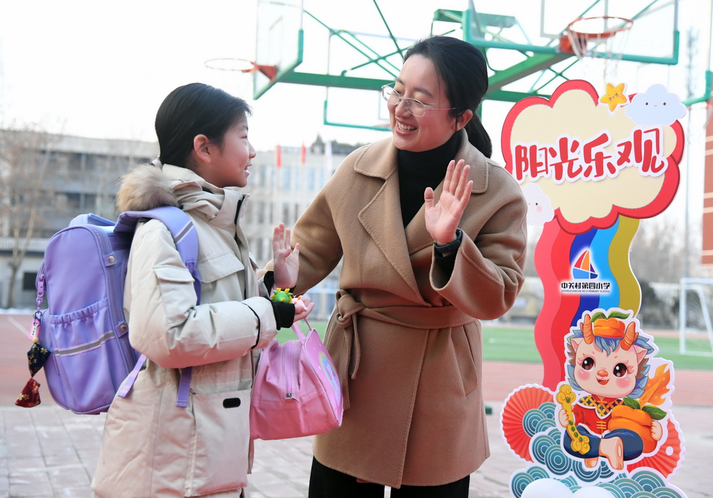 2月26日，在北京市海澱區中關村第四小學，學生與老師相互問候。 新華社記者 任超 攝
