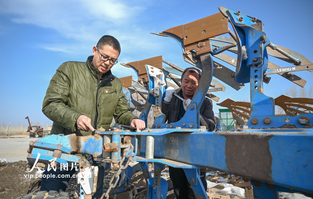 2024年3月11日，在新疆昌吉回族自治州昌吉市何氏農機專業合作社，農機技術人員正在幫助農戶檢修保養農機具。