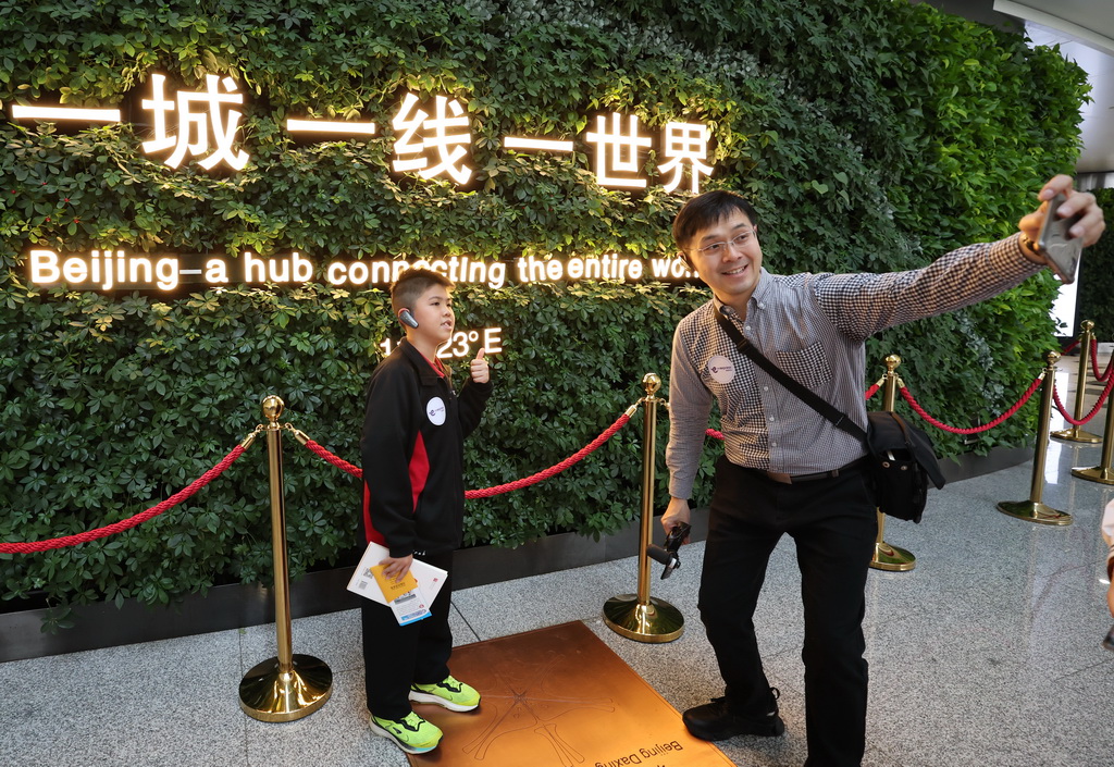3月12日，來自香港的小學生與老師在大興國際機場航站樓內合影留念。