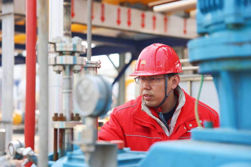大港油田板南儲氣庫運維工程師在生產裝置區查看設備設施運行狀態（2024年3月10日攝）。新華社發（大港油田供圖）