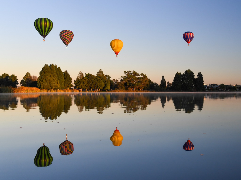 3月20日清晨，放飞的热气球经过新西兰汉密尔顿湖上空。