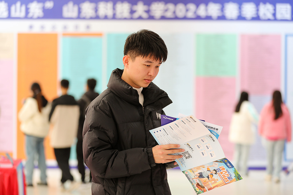 3月21日，山東科技大學輔導員徐昊昊在雙選會現場了解招聘信息。