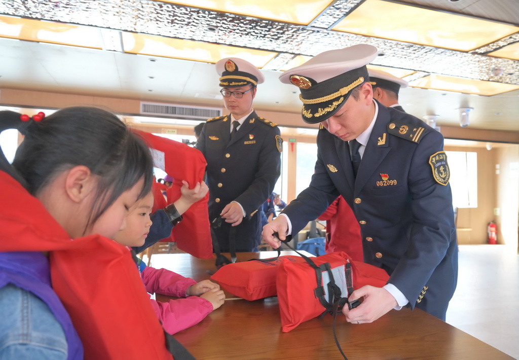 3月24日，福州海事局工作人員在“閩江之戀”號客輪上教學生穿戴救生衣。