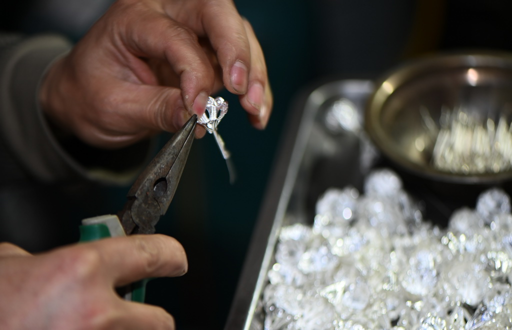  4月8日，手藝人在貴州省黃平縣谷隴鎮一家銀飾店內制作銀飾。新華社發（徐微攝）
