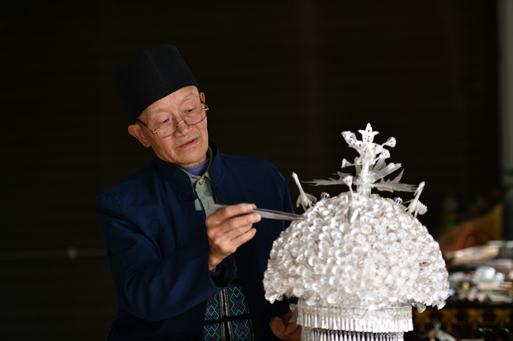 4月8日，在貴州省黃平縣，國家級非遺項目苗族銀飾制作技藝的代表性傳承人楊正貴在自己的工作室中整理一件銀帽。新華社記者 馬寧 攝