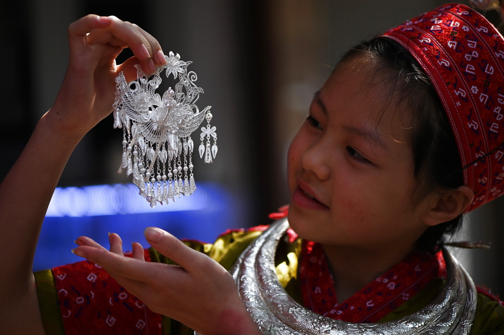 4月8日，小朋友在貴州省黃平縣谷隴鎮銀飾街欣賞一件銀飾品。新華社記者 楊楹 攝