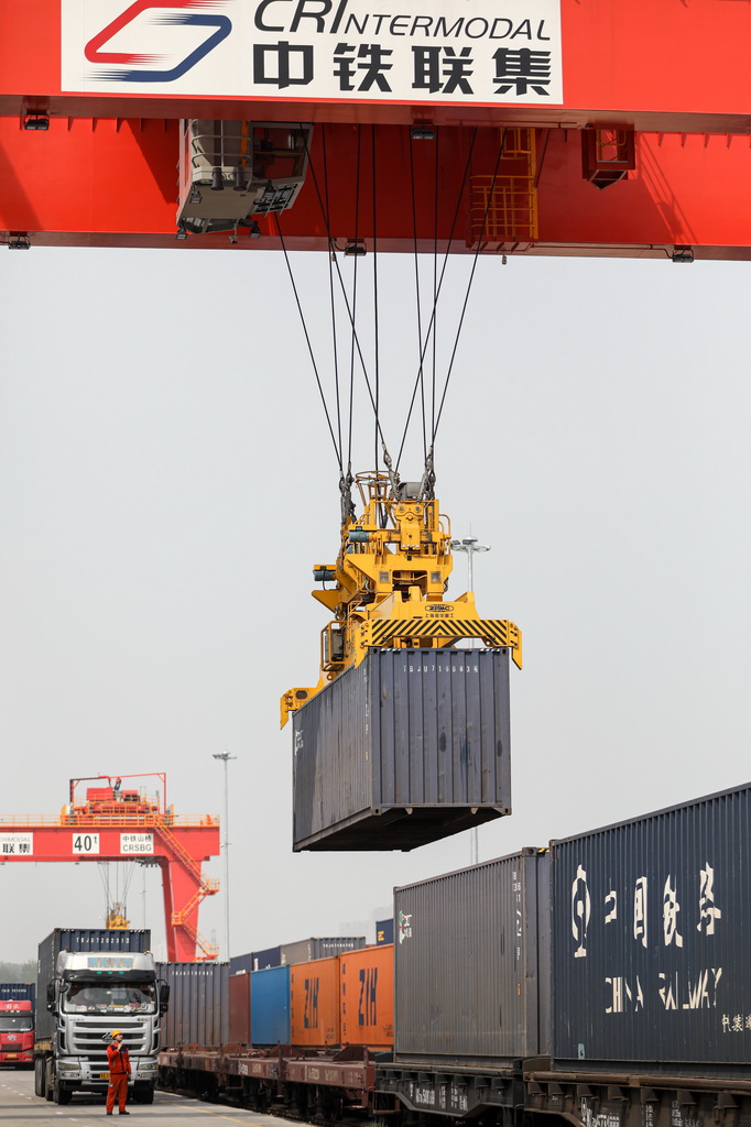 4月11日，在國鐵集團鄭州局圃田站，中鐵聯集的龍門吊向貨運列車上裝載集裝箱。