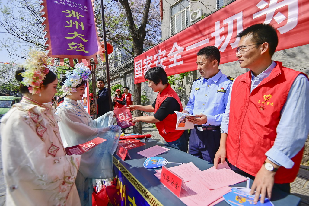 4月13日，在山東省青州古城景區，志願者為游客講解國家安全知識。新華社發（王繼林攝）