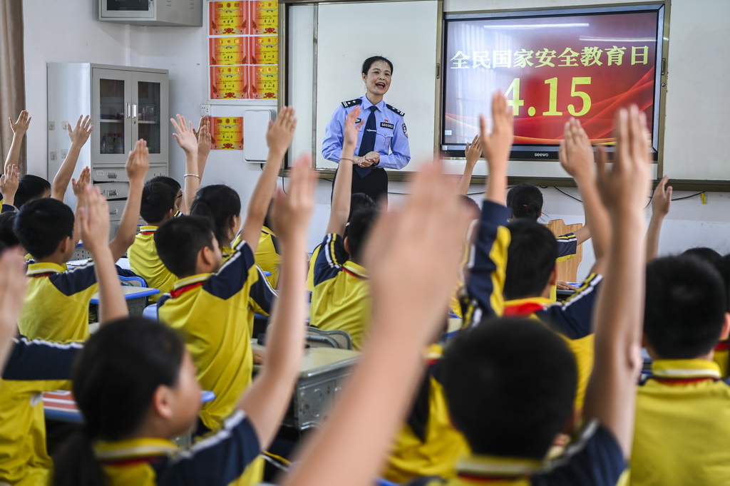 4月15日，在廣西興業縣一所小學內，公安民警在講解國家安全相關知識的過程中與學生們互動。新華社記者 曹祎銘 攝