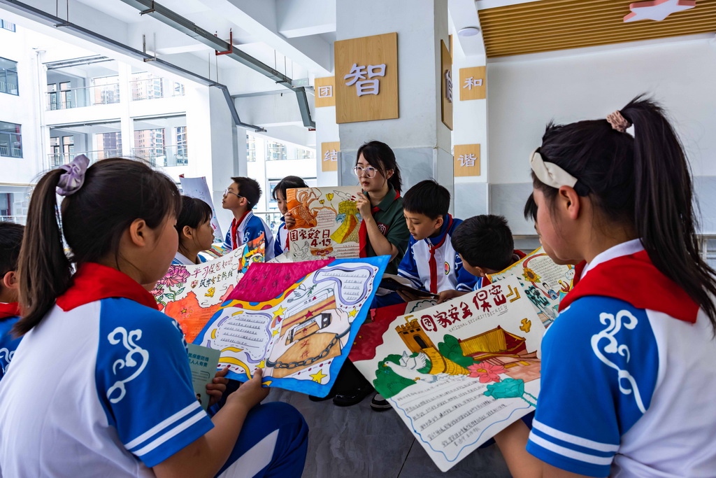 4月15日，貴州省安順市國家保密局宣講員在安順市第七小學點評學生“國家安全日”手抄報。新華社發（陳熙攝）