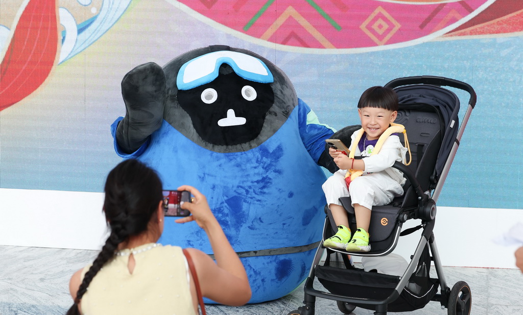 4月17日，小朋友在第四屆消博會主會場與吉祥物合影。新華社記者 楊冠宇 攝